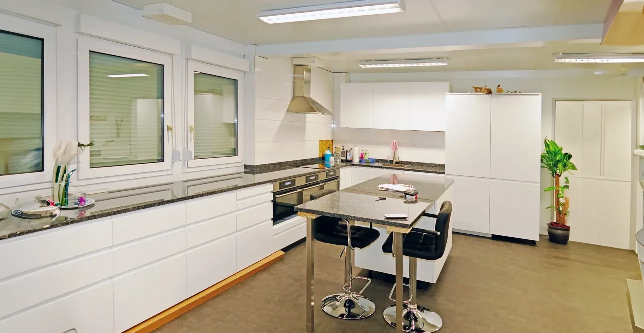 Ett kök med bord och stolar, perfekt för bekvämt boende och utrustat med praktiska servicemoduler för din bekvämlighet.