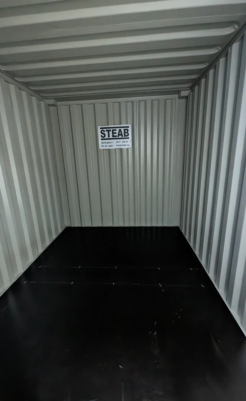 Invändig vy av en tom förvaringscontainer av metall med en Återköpsgaranti-skylt på bakre väggen. Invändig vy av en tom förvaringscontainer av metall med en Återköpsgaranti-skylt på bakre väggen.