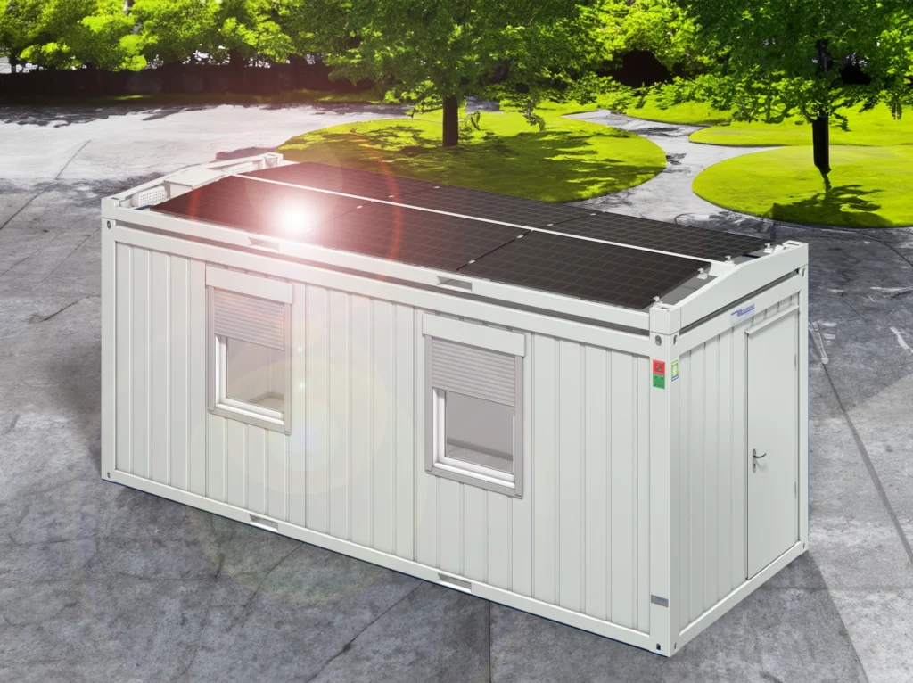 Vitt portabelt containerkontor med solpaneler på taket, placerat utomhus under solljus och träd.
