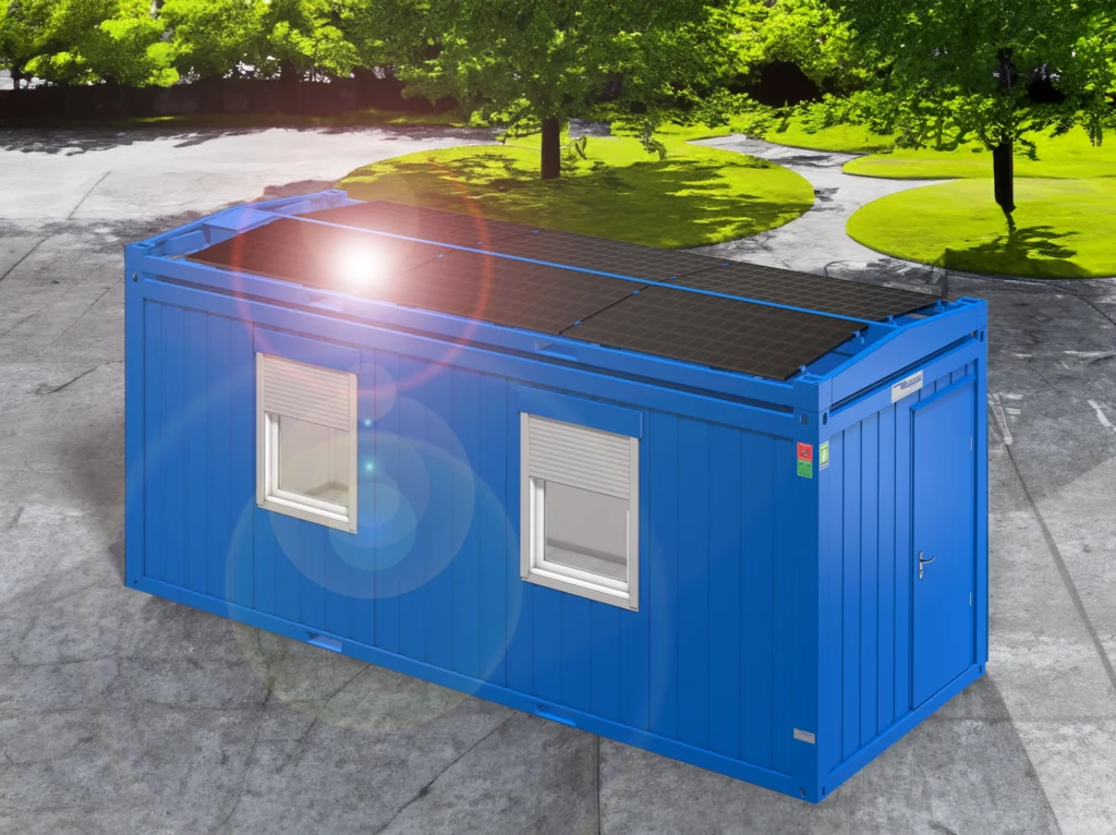 Blå portabel container med fönster och dörr, med solpaneler på taket, placerad på en solig asfalterad yta.